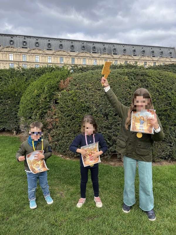 Three smiling children proudly holding their certificates after completing the treasure hunt